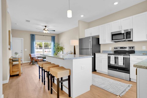 A kitchen with white cabinets and a granite counter top.