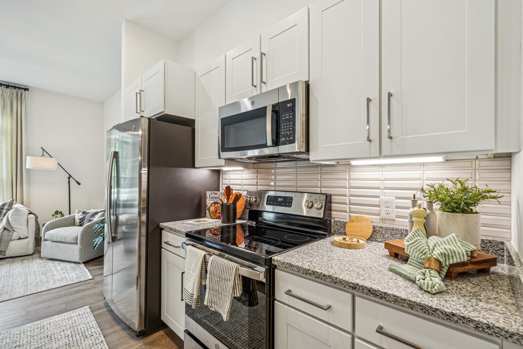 a kitchen with stainless steel appliances and granite counter tops at The Leo Myrtle Beach, Myrtle Beach, SC