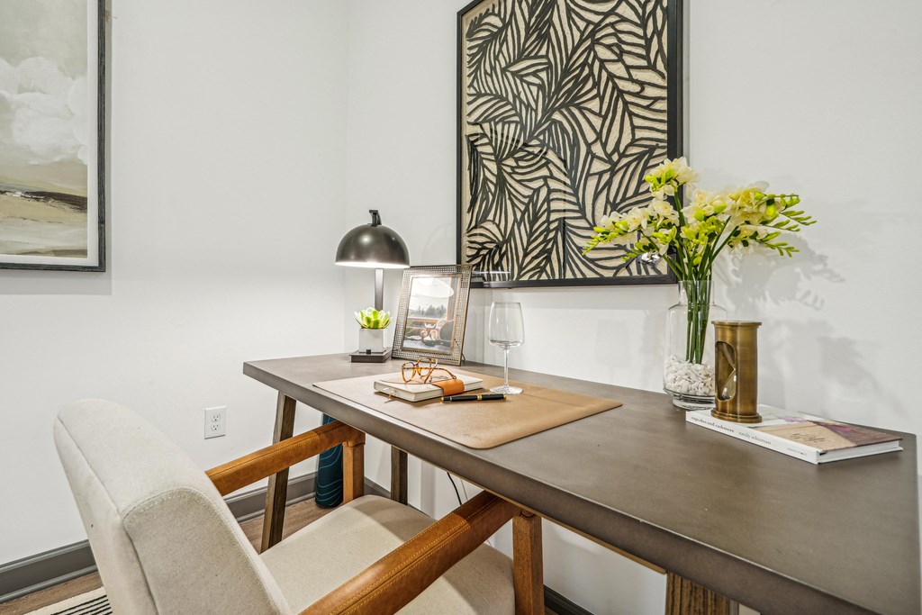 a dining table with a chair and a lamp and a vase of flowers at The Leo Myrtle Beach, Myrtle Beach, 29579