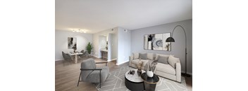 A modern living room with a grey sofa, a round coffee table, and a dining table with chairs.