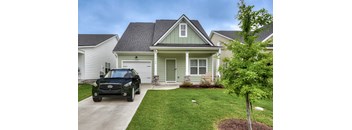 A black car is parked in front of a house.