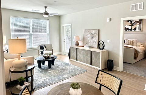 A living room with a grey rug and a black and white painting.