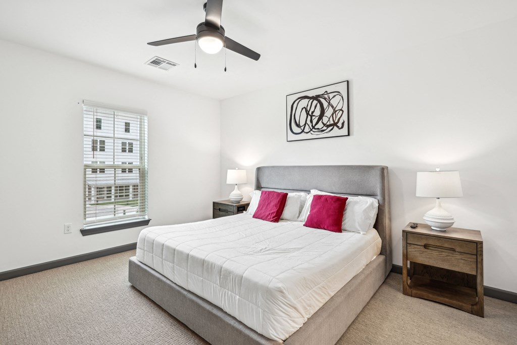 a bedroom with a large bed and a ceiling fan at The Leo Myrtle Beach, South Carolina