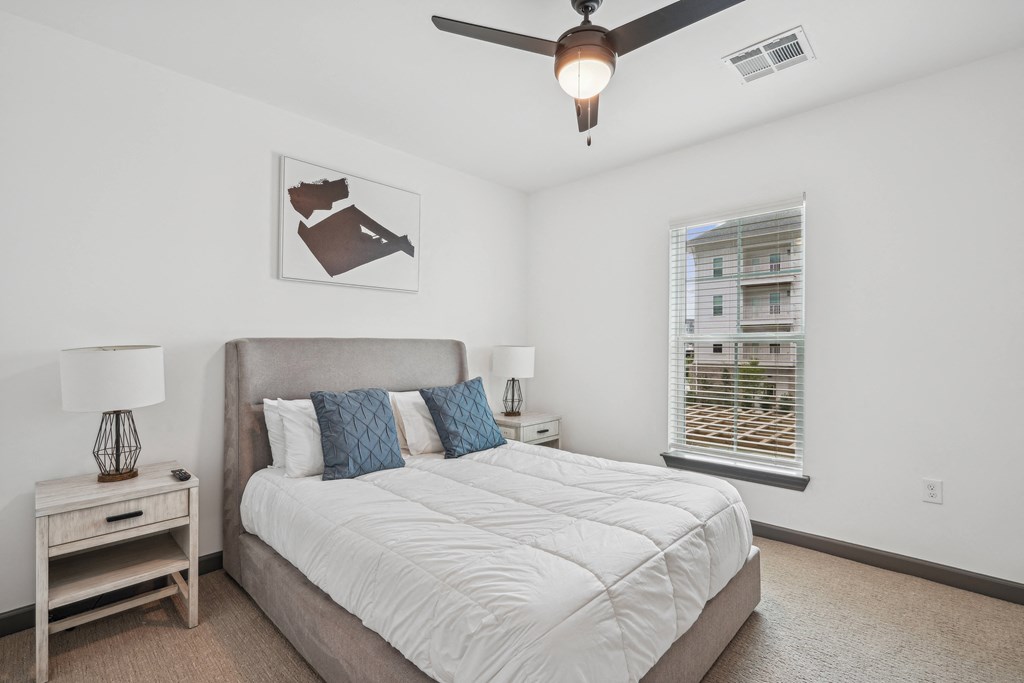 a bedroom with a large bed and a ceiling fan at The Leo Myrtle Beach, Myrtle Beach, SC