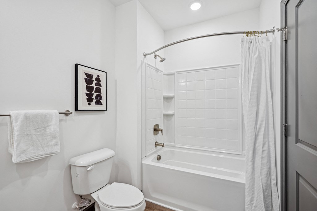 a white bathroom with a shower and a toilet at The Leo Myrtle Beach, South Carolina, 29579