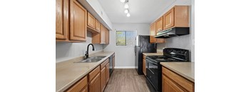 A kitchen with wooden cabinets and black appliances.