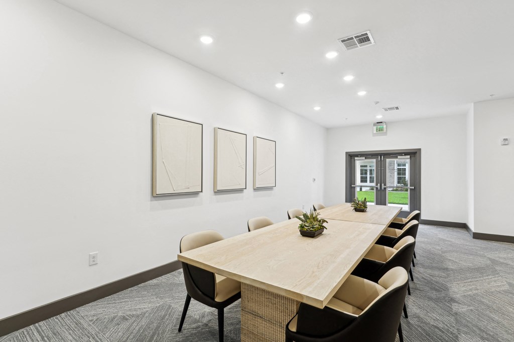 a conference room with white walls and a wooden table and chairs at The Leo Myrtle Beach, Myrtle Beach, SC, 29579