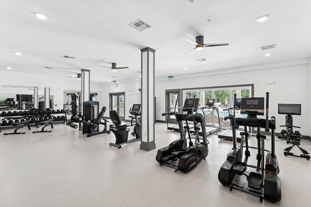 Gym with cardio equipment and weights in a building with windows at The Leo Myrtle Beach, South Carolina, 29579