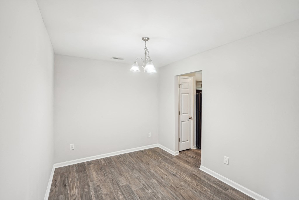 Dining room with a wooden floor and a white door at Lexington on the Green, North Carolina