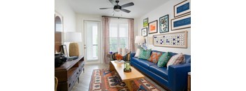 a living room with a blue couch and a ceiling fan