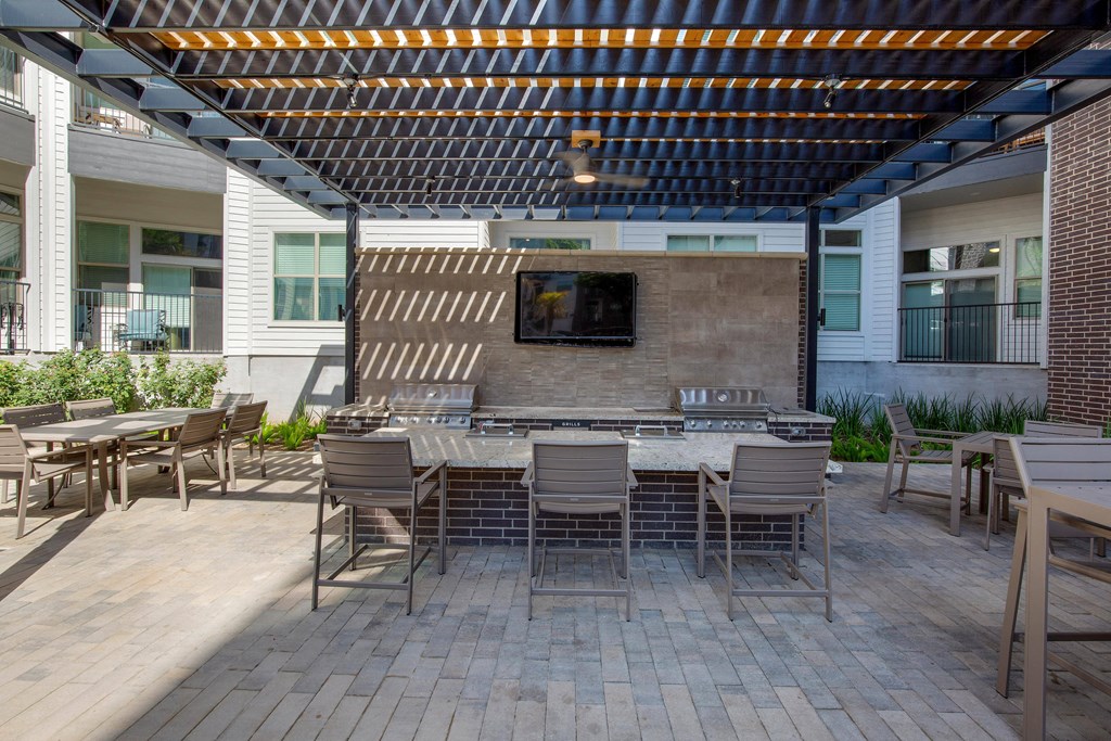 a patio with tables and chairs and a fireplace at The Monroe Apartments, Austin, 78741