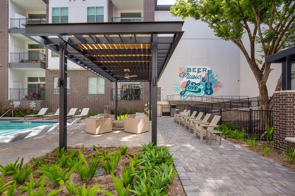 Our apartments have a pool and a patio with benches at The Monroe Apartments, Texas, 78741