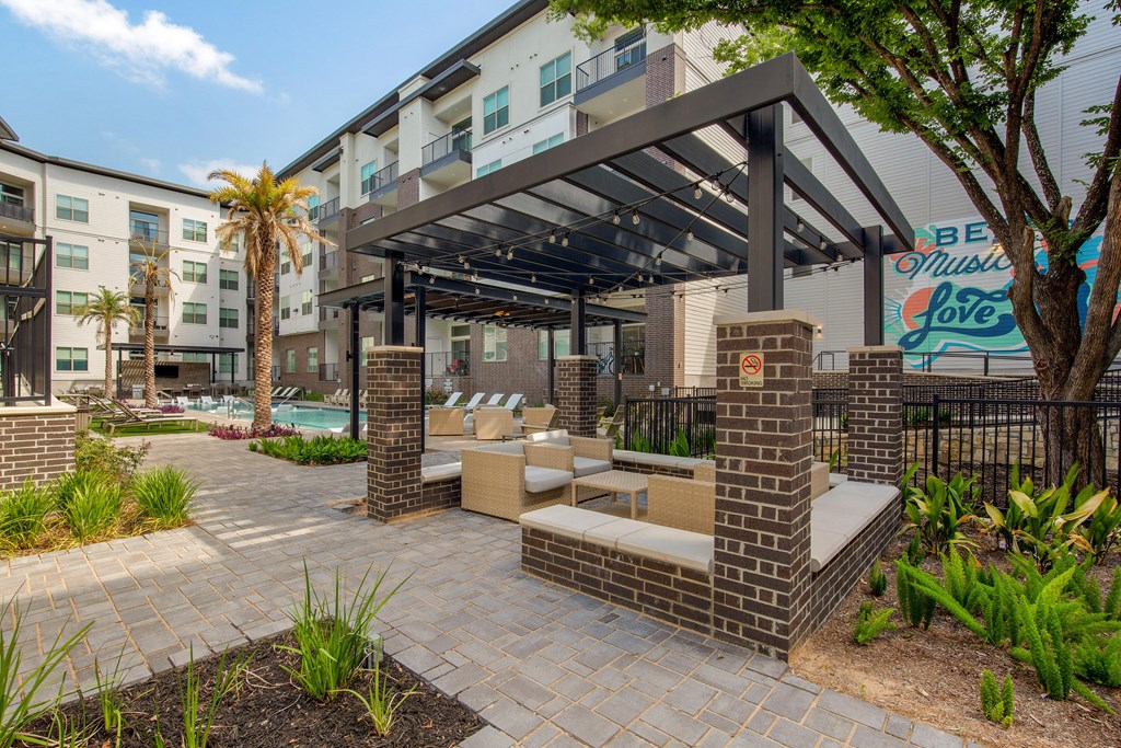 a patio with lounge furniture and a pool at an apartment building at The Monroe Apartments, Texas, 78741