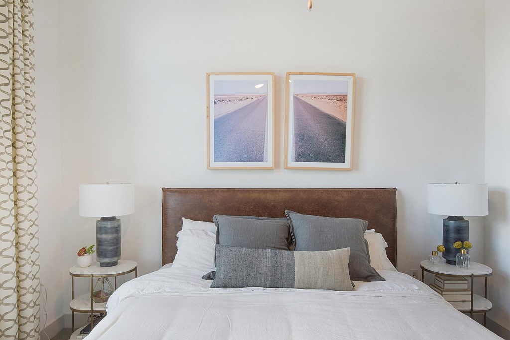 a bedroom with a bed and two pictures on the wall above it at The Monroe Apartments, Austin