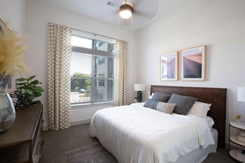 a bedroom with a large bed and a window at The Monroe Apartments, Austin, TX, 78741