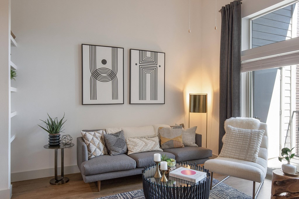 a living room with a couch and two paintings on the wall at The Monroe Apartments, Austin, TX
