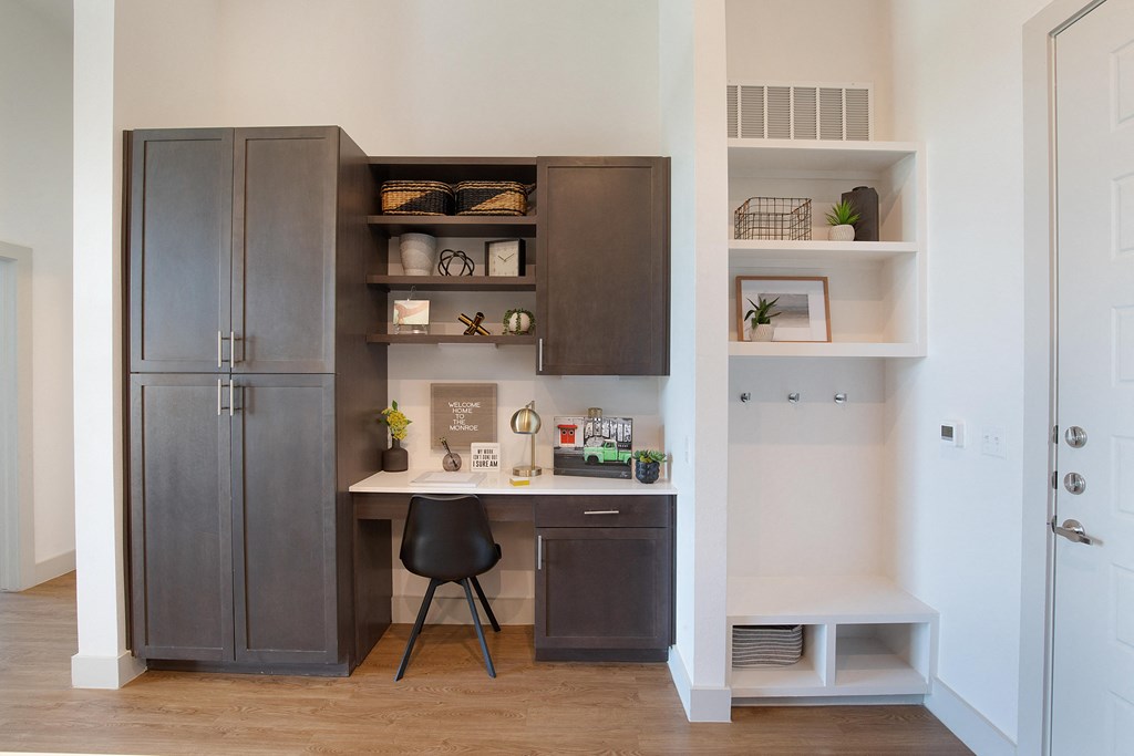 a home office with a desk and a refrigerator at The Monroe Apartments, Austin
