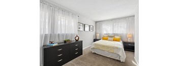 A bedroom with a bed, nightstands, and pictures on the wall.