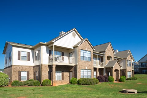 A large, two-story house with a balcony and multiple windows.