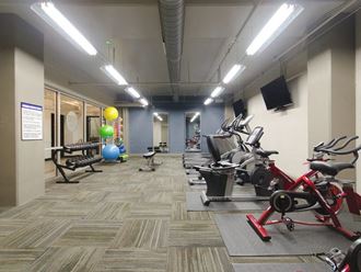 a gym with exercise equipment and a colorful ball