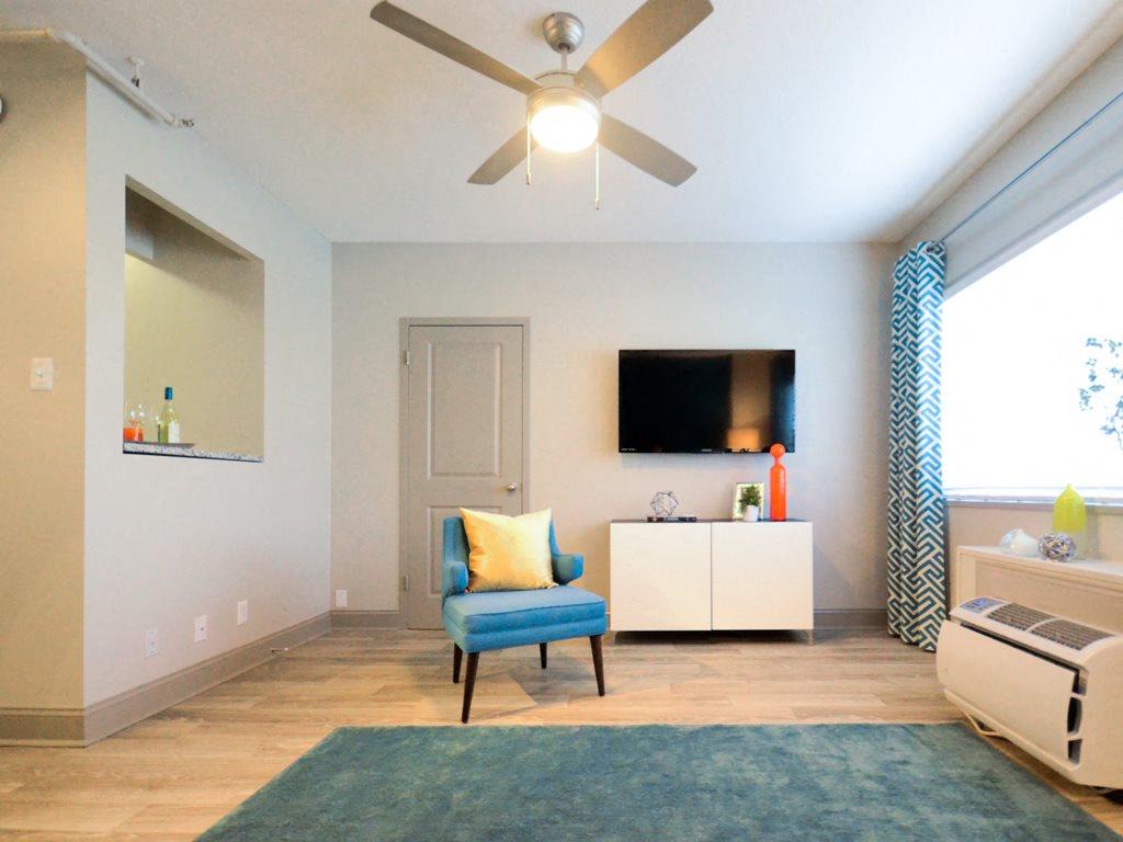 a living room with a ceiling fan and a blue chair