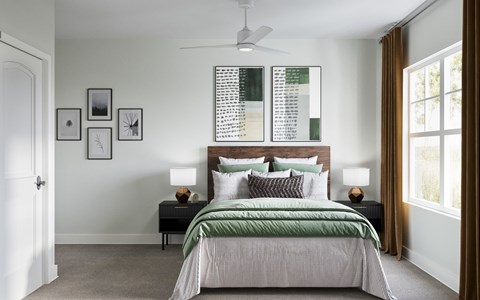 A bedroom with a large bed and a ceiling fan at The SoHo Luxury Apartments, Raleigh, NC