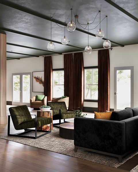 A living room with a black couch and a green chair at The SoHo Luxury Apartments, Raleigh, 27603