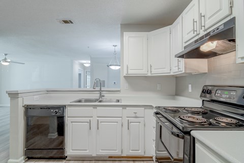 A kitchen with white cabinets and a stainless steel oven.