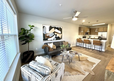 A living room with a couch, a coffee table, and a painting on the wall.