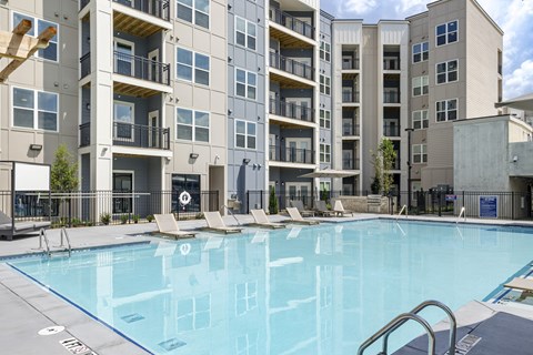 A swimming pool in front of a multi-story apartment building at The Collective Upper Westside Apartments, Atlanta, GA, 30318