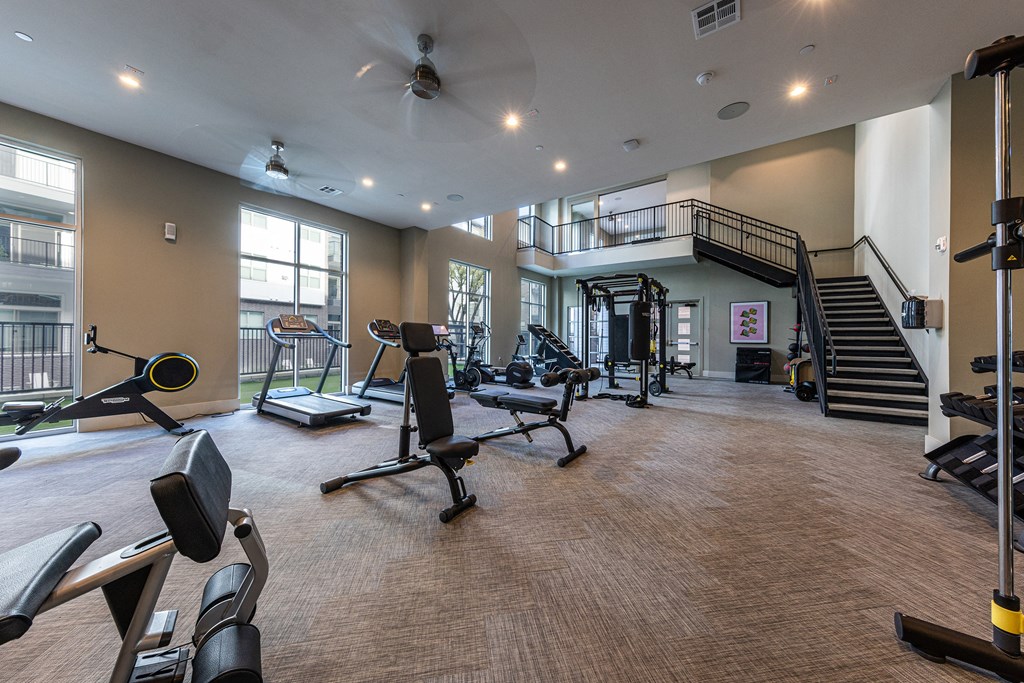 spacious gym with cardio machines and weights at The Monroe Apartments, Austin, 78741
