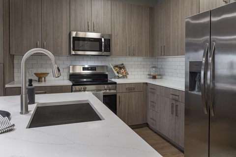 A modern kitchen with a stainless steel refrigerator and a white countertop.