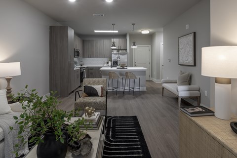 A well-lit, modern living room with a kitchen in the back at The Waverly at Winter Haven Apartments, Florida, 33884