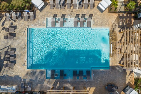 An aerial view of a swimming pool surrounded by lounge chairs.
