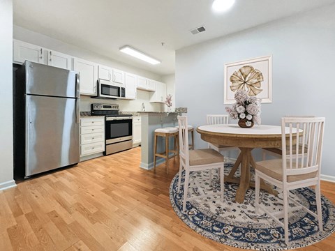 A kitchen with a table and chairs.