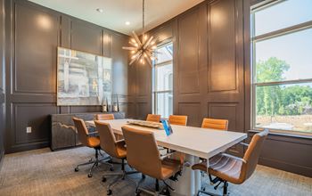A conference room with a long table and chairs at The Ashton at East Park Apartments, Kennesaw, GA, 30144
