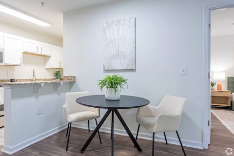 A dining area with a round table and chairs.