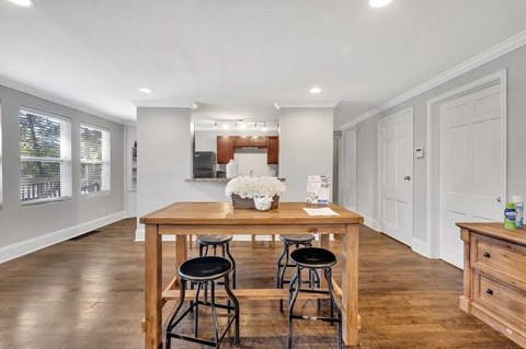 A dining area with a wooden table and chairs.