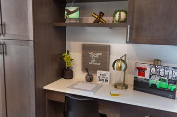 a desk with a laptop and a lamp on it at The Monroe Apartments, Austin