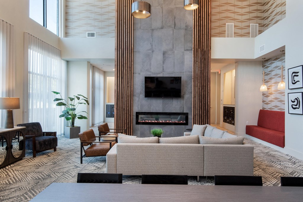 a living room with couches and chairs and a fireplace at The Monroe Apartments, Texas, 78741