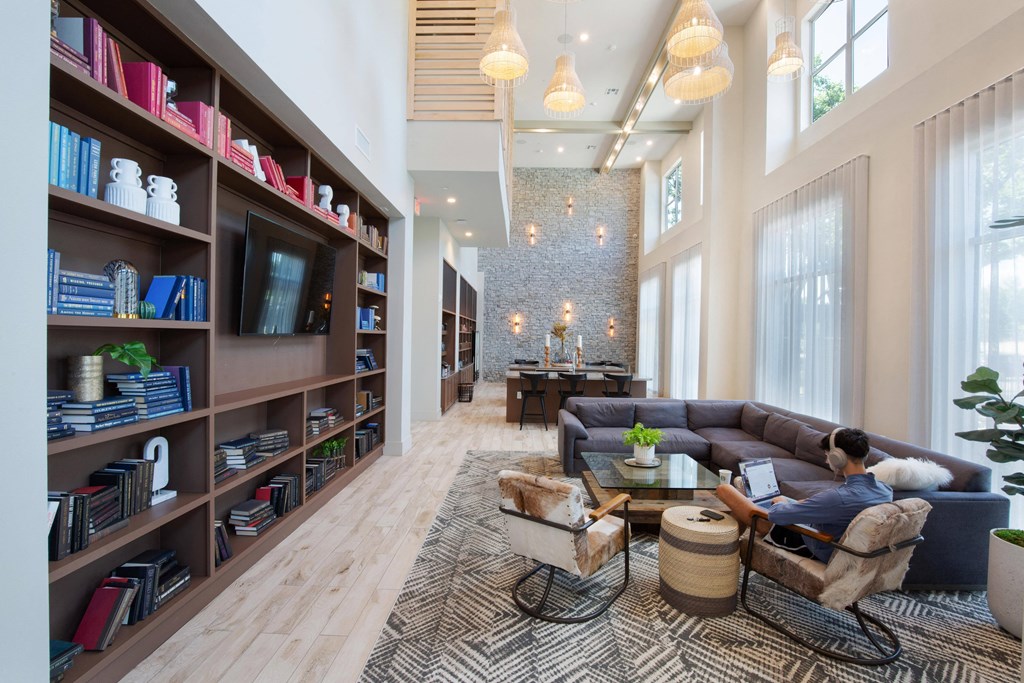 a man sitting on a couch in a living room at The Monroe Apartments, Austin, TX, 78741