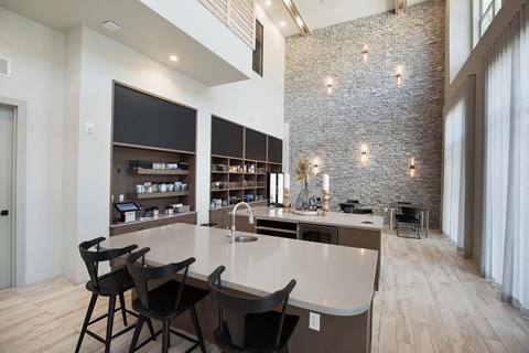 a kitchen with a large island and a dining room with chairs at The Monroe Apartments, Austin, TX