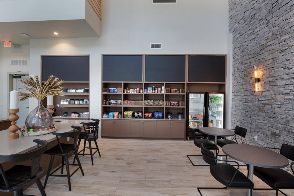 a dining room with tables and chairs and a bar with shelves at The Monroe Apartments, Texas, 78741