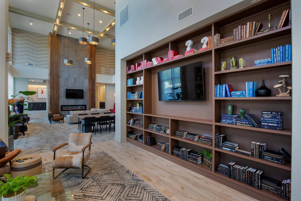 a living room with a large book shelf and a television at The Monroe Apartments, Austin, Texas