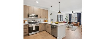 A modern kitchen with wooden cabinets and stainless steel appliances at Union Eleven Apartments, Georgia