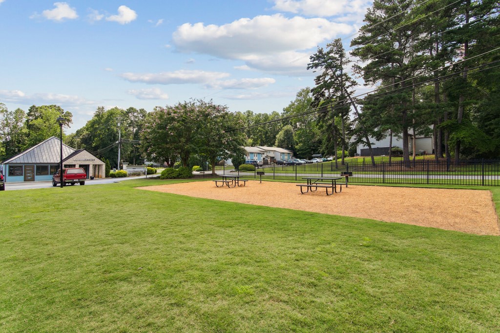 A park with a baseball diamond and a small building.