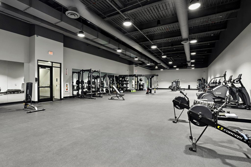 A gym with a variety of exercise equipment including treadmills, weights, and exercise bikes.