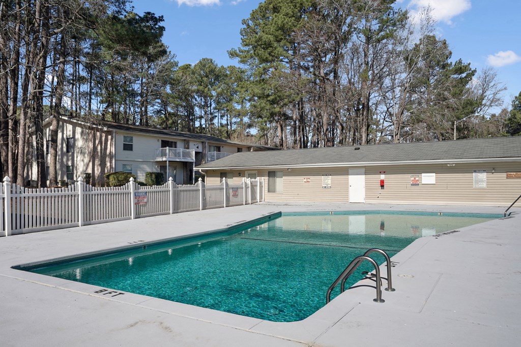a swimming pool with a house in the background