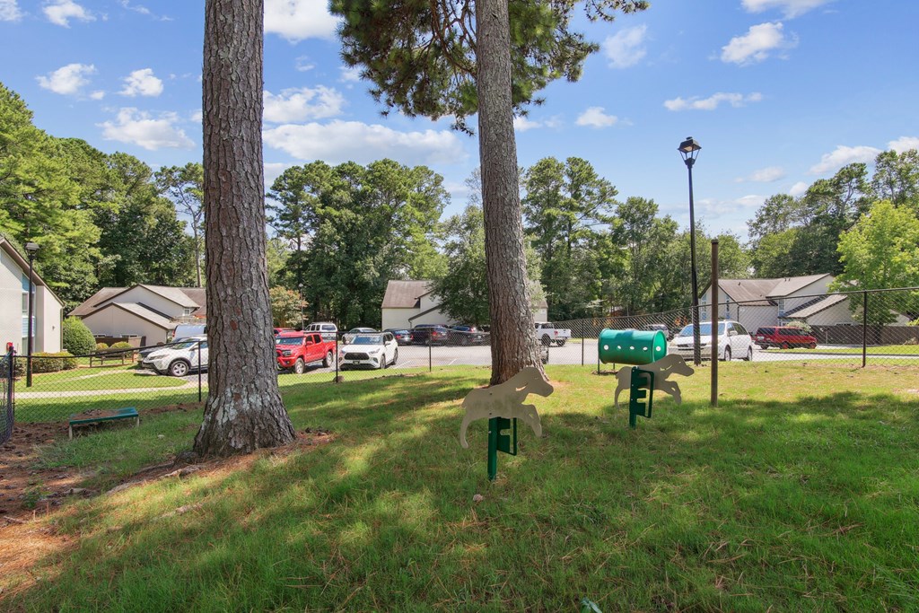 A residential area with houses, trees, and parked cars.