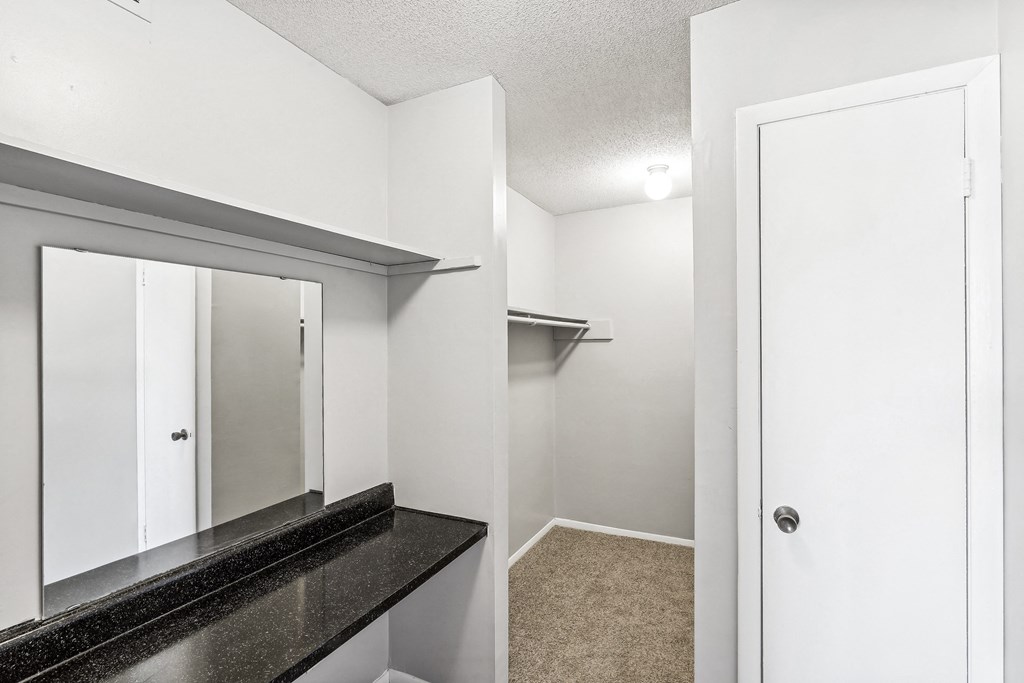 an empty bathroom with a mirror and a closet